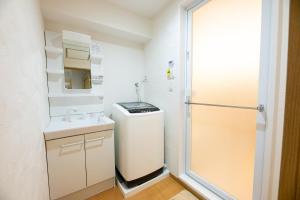 a small bathroom with a sink and a shower at YASAKA Hotel in Kagoshima +41 photos