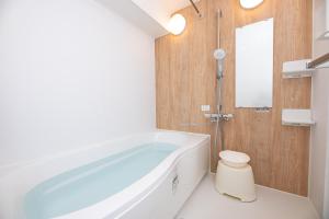 a bathroom with a large tub and a toilet at YASAKA Hotel in Kagoshima