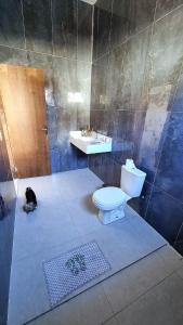 a bathroom with a toilet and a sink and a cat at Milla villa in Alligator Pond Village