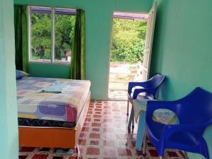 a bedroom with a bed and a table and chairs at Monkey Business Tours & Accommodation in Bukit Lawang