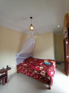 a bedroom with a bed with a mosquito net at Monkey Business Tours & Accommodation in Bukit Lawang