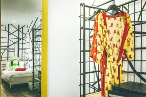 a room with a bed and a rack of clothes at Dash Box Hotel Cyberjaya in Cyberjaya