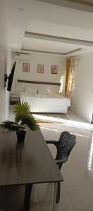 a room with a bed and a table with a plant at Villa Nostra in Ngaparou