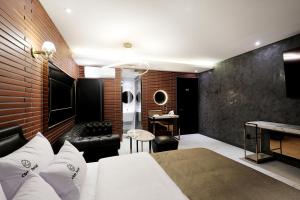 ein Schlafzimmer mit einem weißen Bett und einer Backsteinwand in der Unterkunft Cielo HOTEL in Seosan