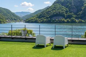 two chairs on a balcony with a view of a river at Chuncheon Rabbit Star Pension in Chuncheon