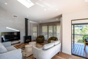 a living room with couches and a television and a balcony at Selah Valley Estate in Limpinwood