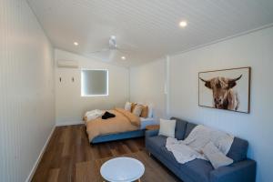 a living room with a couch and a cow picture on the wall at Selah Valley Estate in Limpinwood