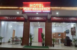 a hotel lobby with a red sign and a restaurant at Vijay Residency in Barkot