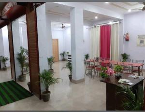 a room with a table and chairs and plants at Vijay Residency in Barkot