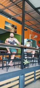 Ein Mann sitzt an einem Tisch in einem Restaurant in der Unterkunft The view Hostel in Ko Phi Phi