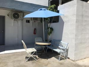 ein Tisch und zwei Stühle und ein Sonnenschirm in der Unterkunft Pearl Point Hotel in Puerto Peñasco
