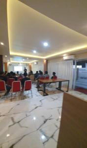 a large room with people sitting at tables and chairs at Hotel & Resto Marza 88 in Pangkajene