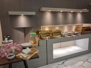 a kitchen with a table and chairs in a restaurant at Hotel & Resto Marza 88 in Pangkajene