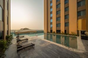 a hotel swimming pool with an umbrella and chairs at Anyla Sầm Sơn Hotels in Sầm Sơn +26 photos
