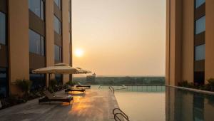 a pool in a building with chairs and an umbrella at Anyla Sầm Sơn Hotels in Sầm Sơn