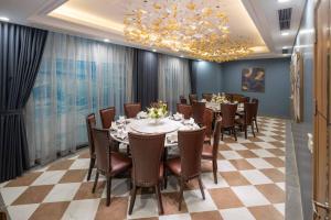 a dining room with a table and chairs and a chandelier at Anyla Sầm Sơn Hotels in Sầm Sơn