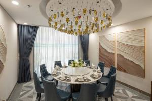 a dining room with a chandelier and a table and chairs at Anyla Sầm Sơn Hotels in Sầm Sơn