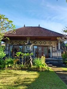 a house with a grass yard in front of it at Okasarna Guesthouse in Sidemen
