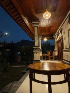 a patio with a wooden table and a dining room at Okasarna Guesthouse in Sidemen