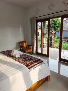 a bedroom with a bed and a sliding glass door at Okasarna Guesthouse in Sidemen