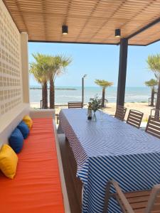 a dining room with a table and a view of the beach at Wind Haus Beachfront Villa in Ban Hat Chao Samran