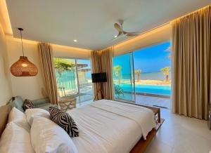 a bedroom with a bed and a view of the ocean at Wind Haus Beachfront Villa in Ban Hat Chao Samran +81 photos