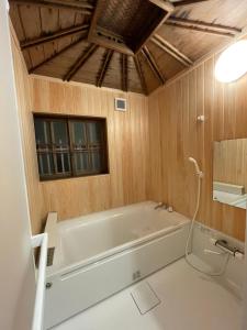 a bath tub in a bathroom with wooden walls at 国登録有形文化財の宿 Hotel 旧若林邸 in Sado