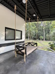 a swinging bed in a room with a large window at Luxury Riverfront House 3BR BBQ Jungle views & walk to river in Parrita