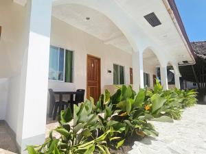 a house with a bunch of plants in front of it at Mangoverde Guesthouse in Moalboal