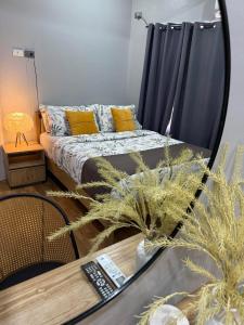 a bedroom with a bed with yellow pillows and a table at La Casa Guillermo in San Isidro