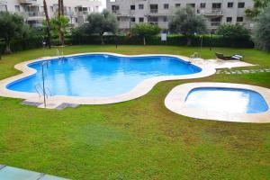 a large swimming pool in a yard with grass at OFFLINE - Altos in Torremolinos