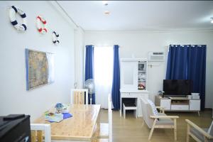 a living room with a dining table and a desk at Condotel in SM Trece Martires in Trece Martires