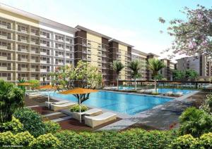an exterior view of a building with a swimming pool at Condotel in SM Trece Martires in Trece Martires