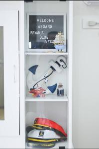 a white refrigerator filled with hats and a sign at Condotel in SM Trece Martires in Trece Martires