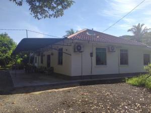 a small white house with a black roof at Homestay kampung dusun in Balik Pulau +21 photos