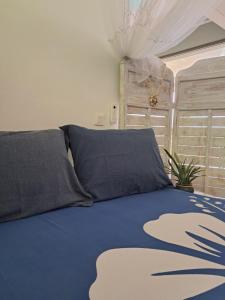a bedroom with a bed with a blue comforter at ARIIMOE Hava'e in Teahupoo