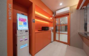 an orange room with a vending machine in a kitchen at No 25 Iksan Station Branch in Iksan +40 photos