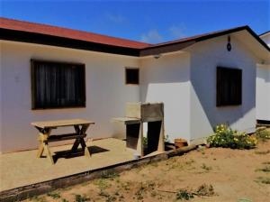 a picnic table in front of a house at Cabañas Vista Parapentes in Maitencillo