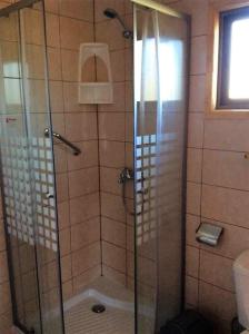 a shower with a glass door in a bathroom at Cabañas Vista Parapentes in Maitencillo +149 photos
