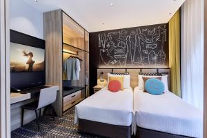 a hotel room with two beds and a desk at Citadines Namba Osaka in Osaka