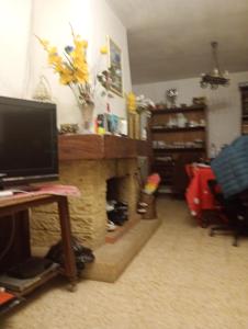 ein Wohnzimmer mit Kamin und ein Schreibtisch mit Computer in der Unterkunft Gillet in LʼIsle-sur-la-Sorgue