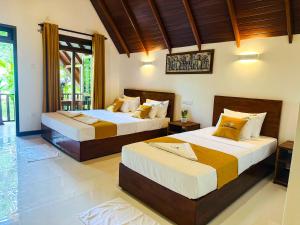a bedroom with two beds and a window at Oak Haven Cabana Sigiriya in Sigiriya