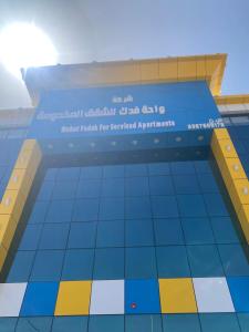 a building with a sign for the united arab emirates at واحه فدك للشقق المخدومه in Al Ḩāyiţ