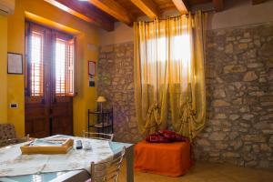 a dining room with a table and a stone wall at Casa Vacanze Caccamo Santa Lucia in Caccamo