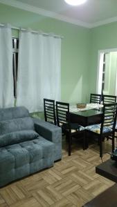 sala de estar con sofá y mesa con sillas en Apartamento Pitangueiras - Guaruja, en Guarujá