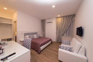 a hotel room with a bed and a couch at Dea Guest House in Sorrento