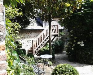 a stairway with a table and a tree in a garden at La Cour Sainte Catherine demeure de charme in Honfleur