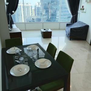 a dining table with plates and glasses on it in a room at Vortex suites klcc by kl cozy home in Kuala Lumpur