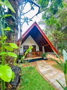 a house with a red roof in a forest at Oak Haven Cabana Sigiriya in Sigiriya