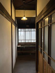 an empty hallway in an old building with a window at 国登録有形文化財の宿 Hotel 旧若林邸 in Sado
